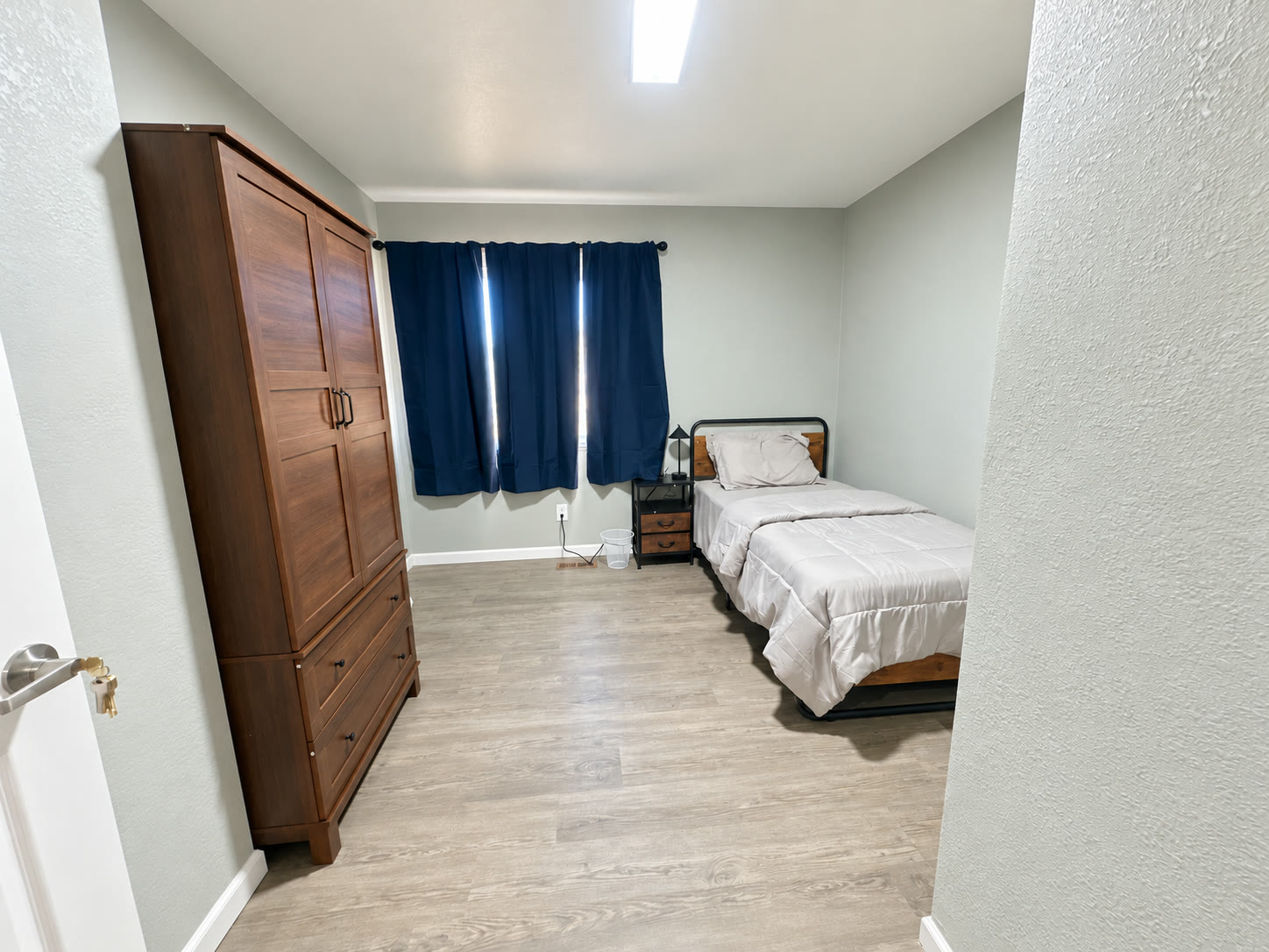 Private bedroom suite at Brown Circle Haven with wood armoire and comfortable bed