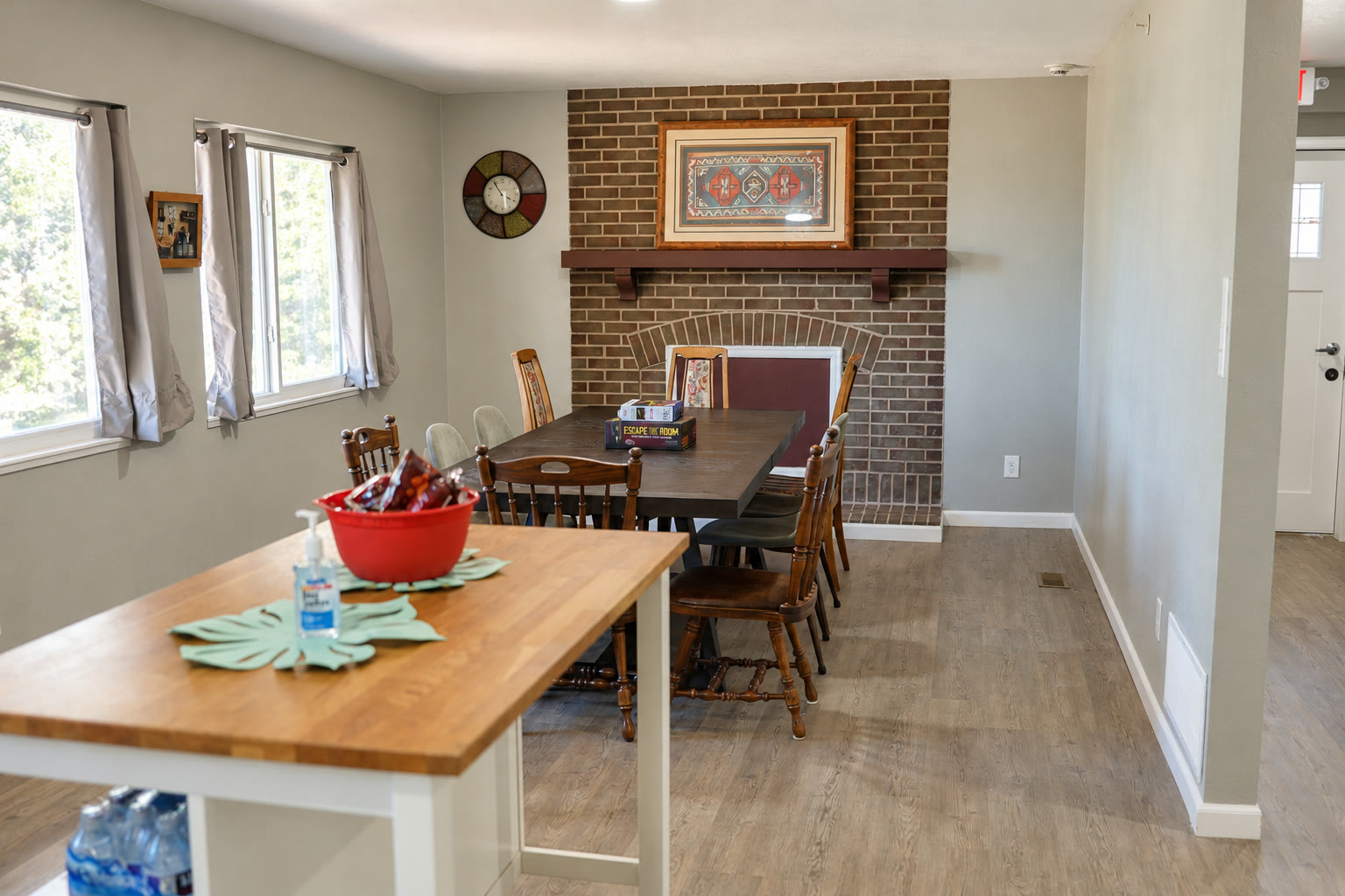 Communal dining table beside warm brick fireplace mantel at Brown Circle Haven